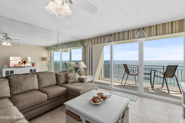 living room featuring a wealth of natural light, a water view, ceiling fan, and light tile patterned floors