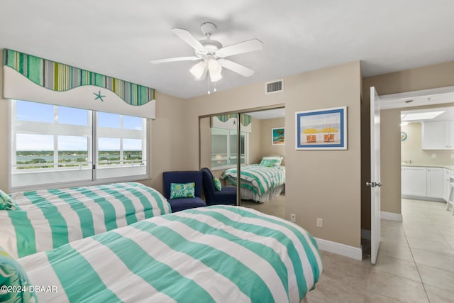 bedroom featuring a closet, light tile patterned floors, and ceiling fan