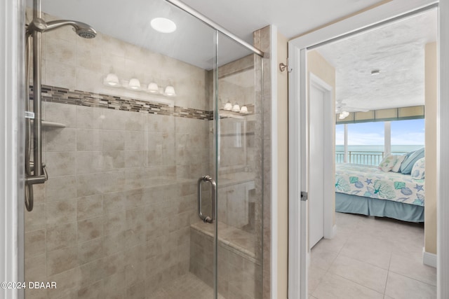 bathroom featuring tile patterned flooring, ceiling fan, and a shower with shower door