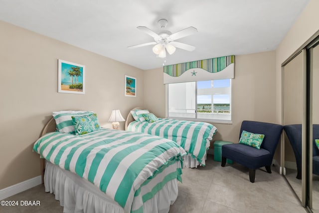 tiled bedroom featuring ceiling fan and a closet