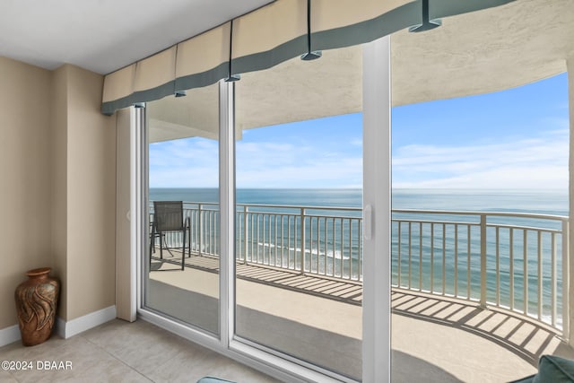 balcony featuring a view of the beach and a water view