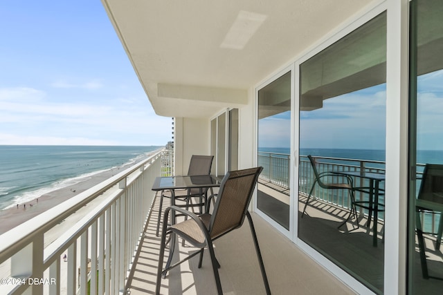 balcony featuring a beach view and a water view