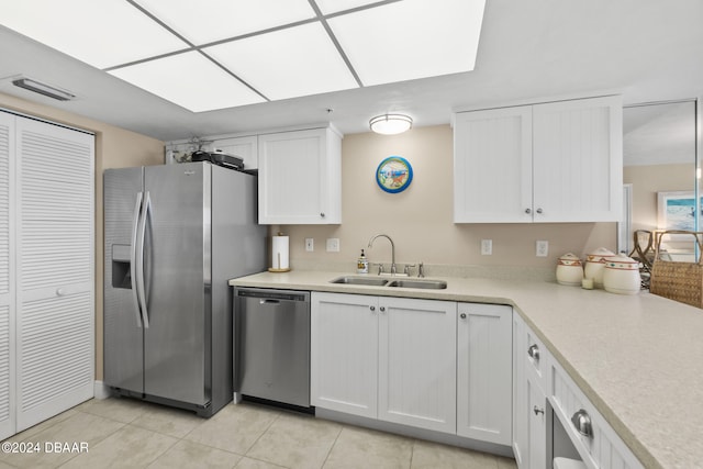 kitchen featuring white cabinetry, appliances with stainless steel finishes, sink, and light tile patterned floors