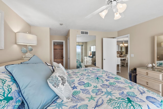 bedroom with ceiling fan with notable chandelier and ensuite bath