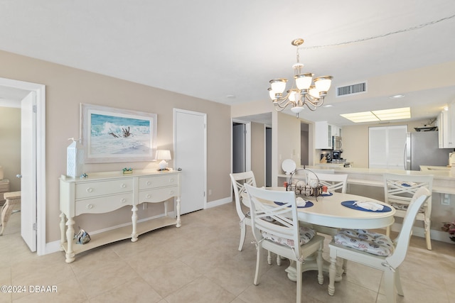 dining area featuring light tile patterned floors and an inviting chandelier