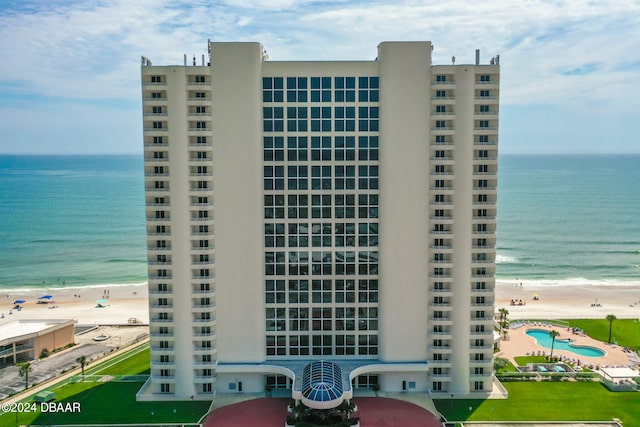 view of building exterior featuring a view of the beach and a water view