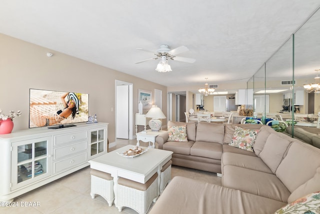 living room featuring ceiling fan with notable chandelier and light tile patterned flooring