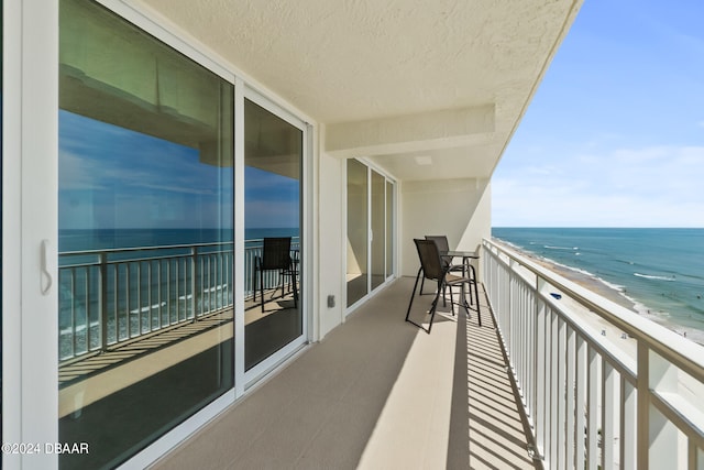 balcony featuring a beach view and a water view