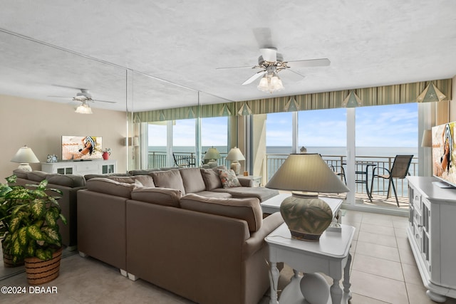 tiled living room with a textured ceiling, a healthy amount of sunlight, and ceiling fan