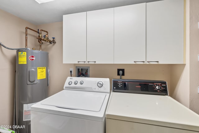 laundry area with electric water heater, separate washer and dryer, and cabinets