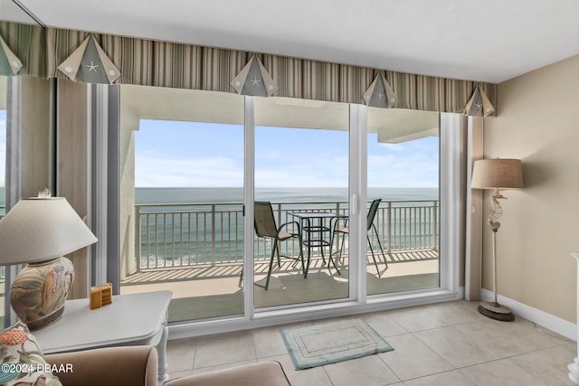 doorway to outside featuring a water view and light tile patterned floors