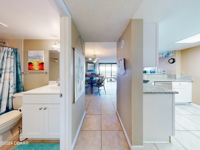 interior space featuring a textured ceiling, light tile patterned flooring, and sink