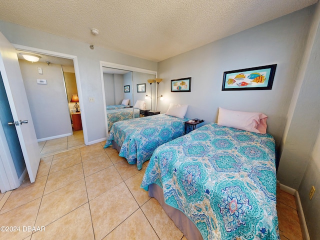 bedroom featuring a textured ceiling and light tile patterned floors