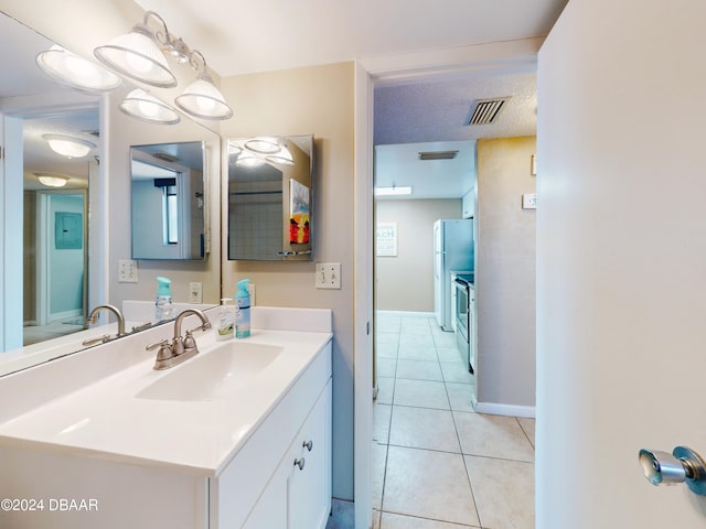 bathroom featuring tile patterned flooring, vanity, and a textured ceiling