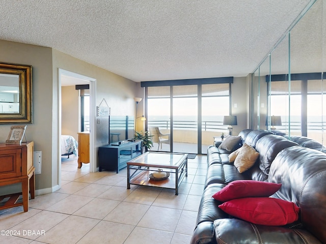 tiled living room featuring a textured ceiling and floor to ceiling windows