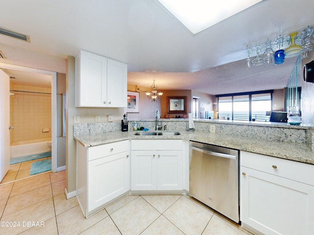 kitchen featuring dishwasher, sink, light tile patterned flooring, and white cabinets