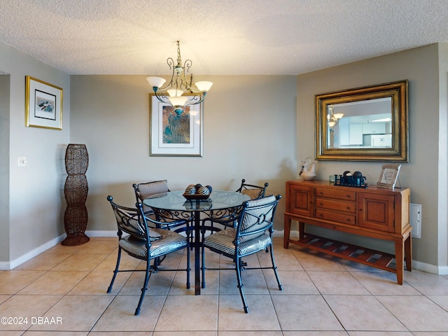 tiled dining room with a textured ceiling and a notable chandelier