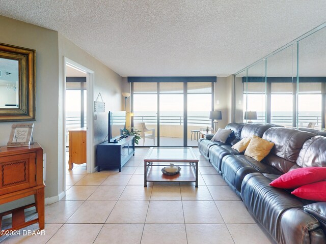 tiled living room with a wall of windows and a textured ceiling