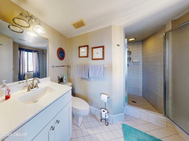 bathroom featuring vanity, walk in shower, tile patterned floors, and toilet