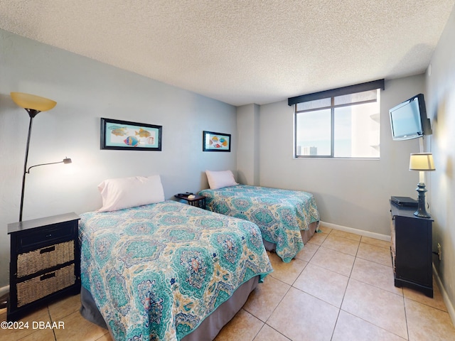 bedroom with a textured ceiling and light tile patterned floors