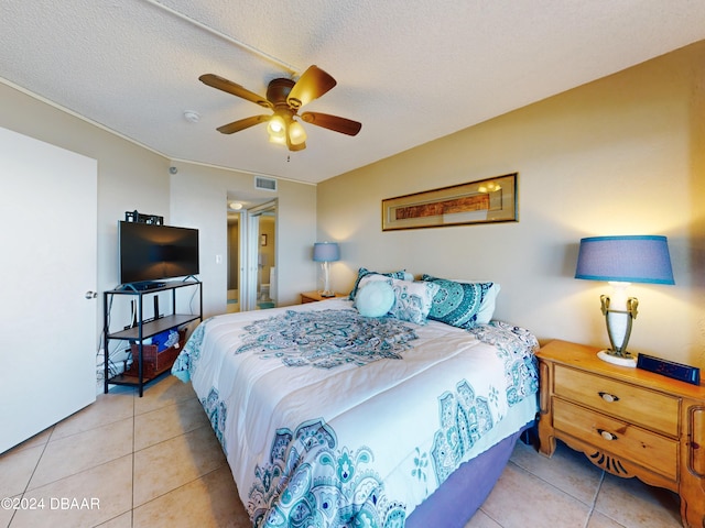 tiled bedroom featuring a textured ceiling and ceiling fan