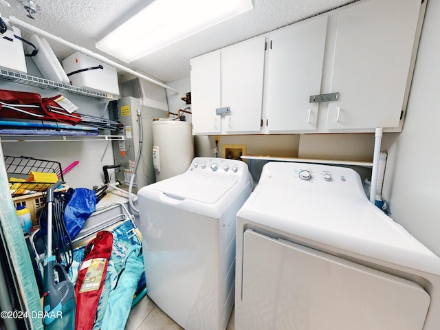 laundry room featuring a textured ceiling, cabinets, gas water heater, and independent washer and dryer