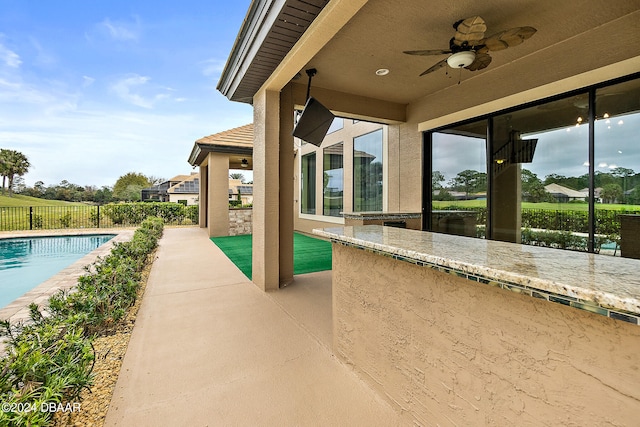 view of swimming pool featuring ceiling fan and a patio area