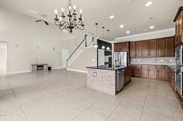 kitchen with a center island with sink, ornamental molding, backsplash, appliances with stainless steel finishes, and pendant lighting