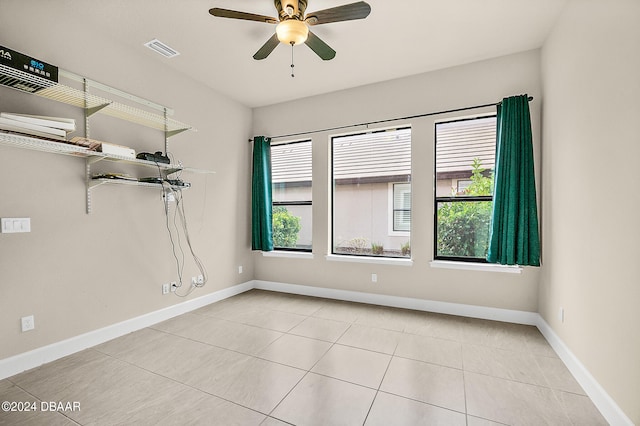 tiled spare room with ceiling fan