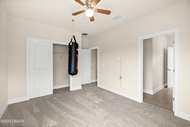 unfurnished bedroom featuring carpet flooring, ceiling fan, and a closet