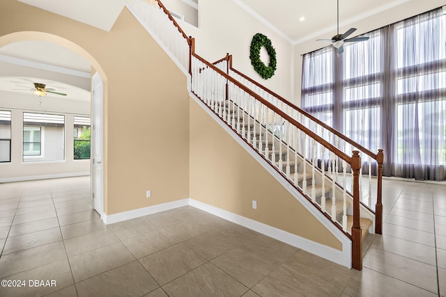 stairs featuring ornamental molding, tile patterned flooring, and plenty of natural light