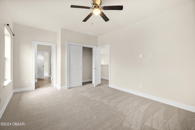 unfurnished bedroom featuring light carpet, ceiling fan, and a closet