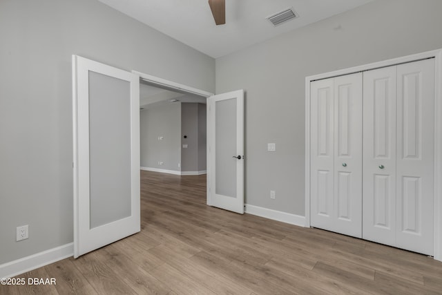 unfurnished bedroom featuring ceiling fan, light hardwood / wood-style floors, and a closet