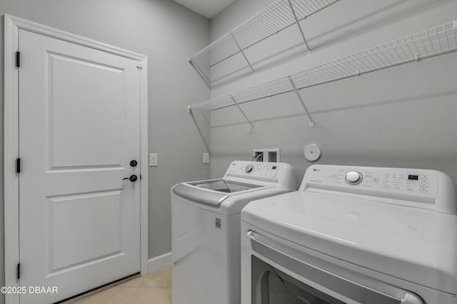 laundry area featuring washing machine and dryer and light tile patterned floors