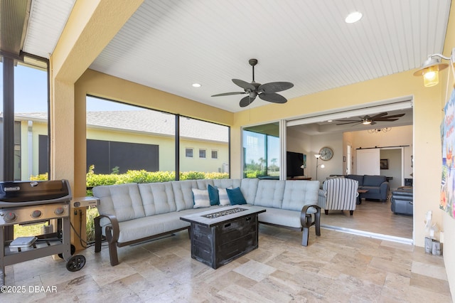 sunroom with a barn door and a ceiling fan