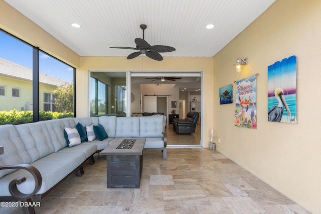 interior space with a garage, an outdoor living space with a fire pit, and ceiling fan