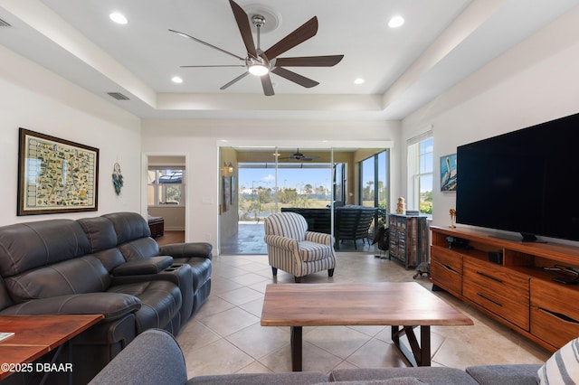 living room featuring a wealth of natural light, a raised ceiling, and visible vents