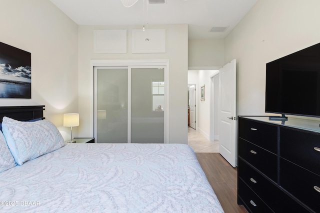 bedroom with a closet, visible vents, and wood finished floors