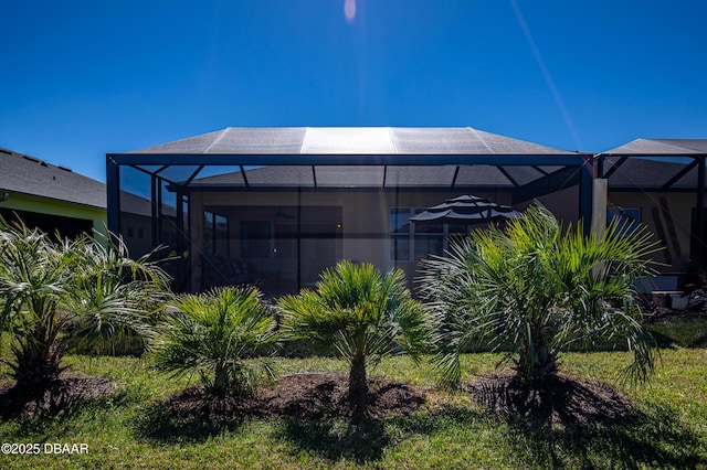 rear view of property featuring glass enclosure