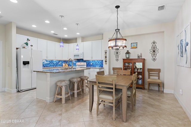 dining space featuring light tile patterned floors, baseboards, visible vents, an inviting chandelier, and recessed lighting