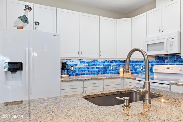 kitchen featuring light stone counters, white appliances, white cabinets, and tasteful backsplash