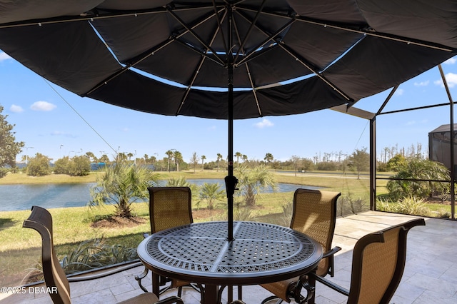 view of patio featuring a lanai, a water view, and outdoor dining area