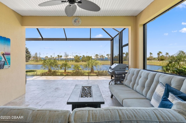 sunroom / solarium featuring a water view and a ceiling fan