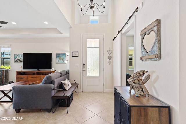 foyer with a healthy amount of sunlight, light tile patterned floors, a barn door, and recessed lighting