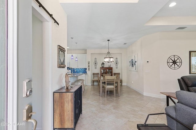 dining room featuring light tile patterned flooring, visible vents, baseboards, and a barn door