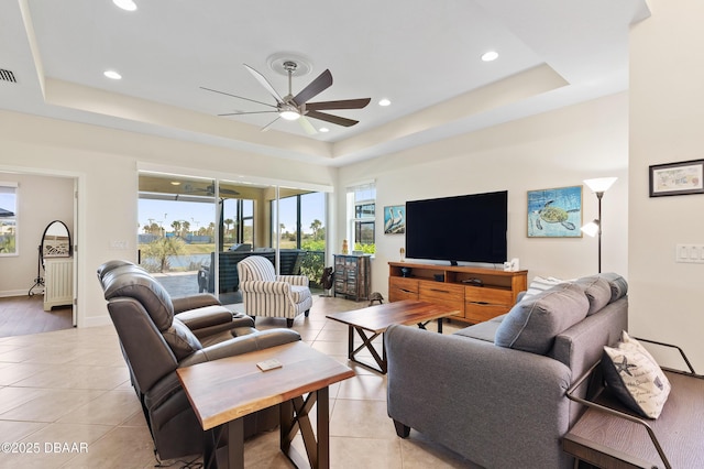 living area with light tile patterned floors, a tray ceiling, a ceiling fan, and recessed lighting