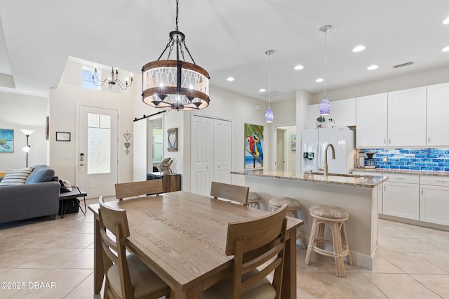 dining area featuring recessed lighting, visible vents, a barn door, light tile patterned flooring, and a chandelier