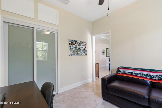 interior space with light tile patterned floors, baseboards, visible vents, and a ceiling fan