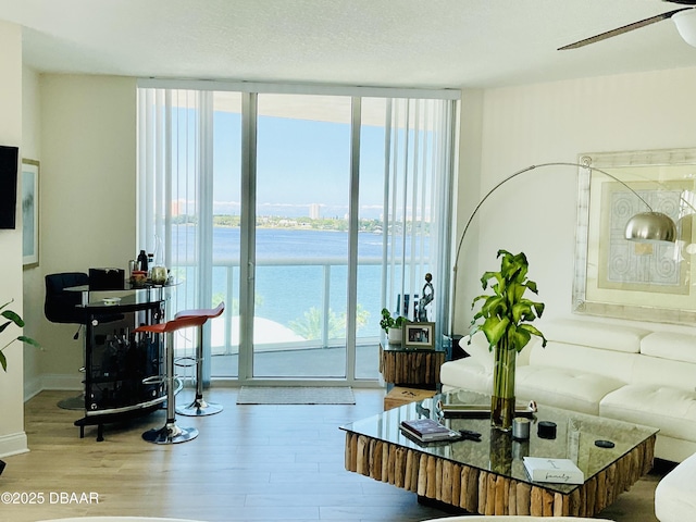 241 Riverside Dr Unit 710, Daytona Beach, FL 32117 - living area with a water view, a wall of windows, plenty of natural light, and wood finished floors