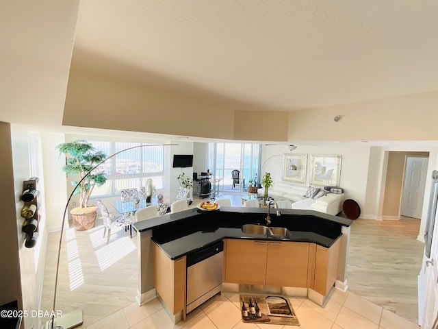 241 Riverside Dr Unit 710, Daytona Beach, FL 32117 - kitchen featuring light brown cabinets, stainless steel dishwasher, a sink, open floor plan, and dark countertops
